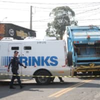 Police officers are seen near a site where an armed gang held people hostage after they robbed a securities company at the Viracopos airport freight terminal, in Campinas near Sao Paulo Thursday. | REUTERS