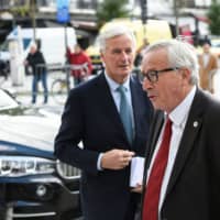 President of the European Commission Jean-Claude Juncker (right) and EU chief Brexit negotiator Michel Barnier arrive for a European Union summit at the European Union headquarters in Brussels on Thursday. | AFP-JIJI