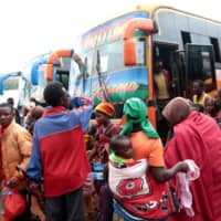 Burundian refugees get off from a bus that transported them from Tanzania to neighboring Burundi as part of a repartition program, at the Nyabitare transit site in the Gisuru commune, Ruyigi province, Burundi, Thursday. | REUTERS