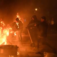 Protesters burn garbage containers during protests in Barcelona, Spain, on Tuesday. | AFP-JIJI