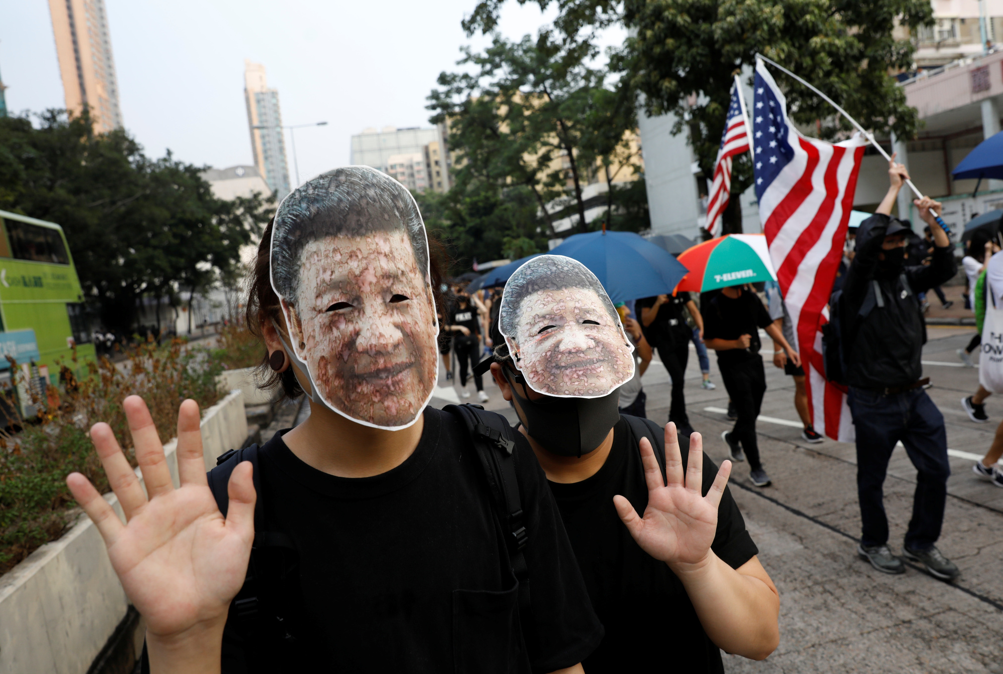 Anti-government demonstrators wear masks bearing the image of Chinese President Xi Jinping during a protest against the invocation of the emergency laws in Hong Kong on Oct. 12. | REUTERS