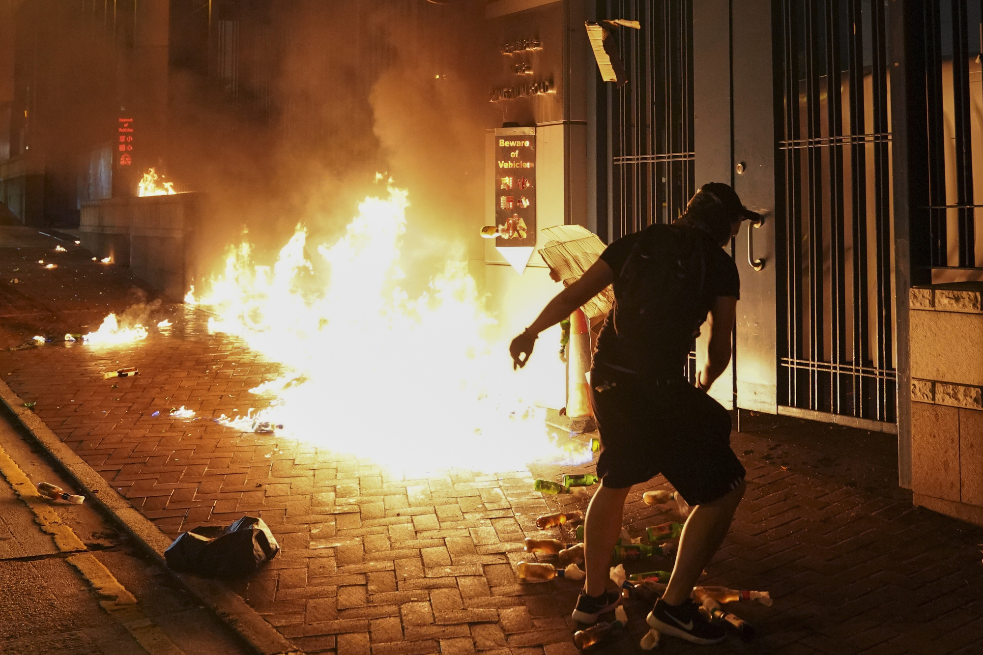 A protester throws a gasoline bomb outside the Tsuen Wan police station in Hong Kong on Wednesday. | AP