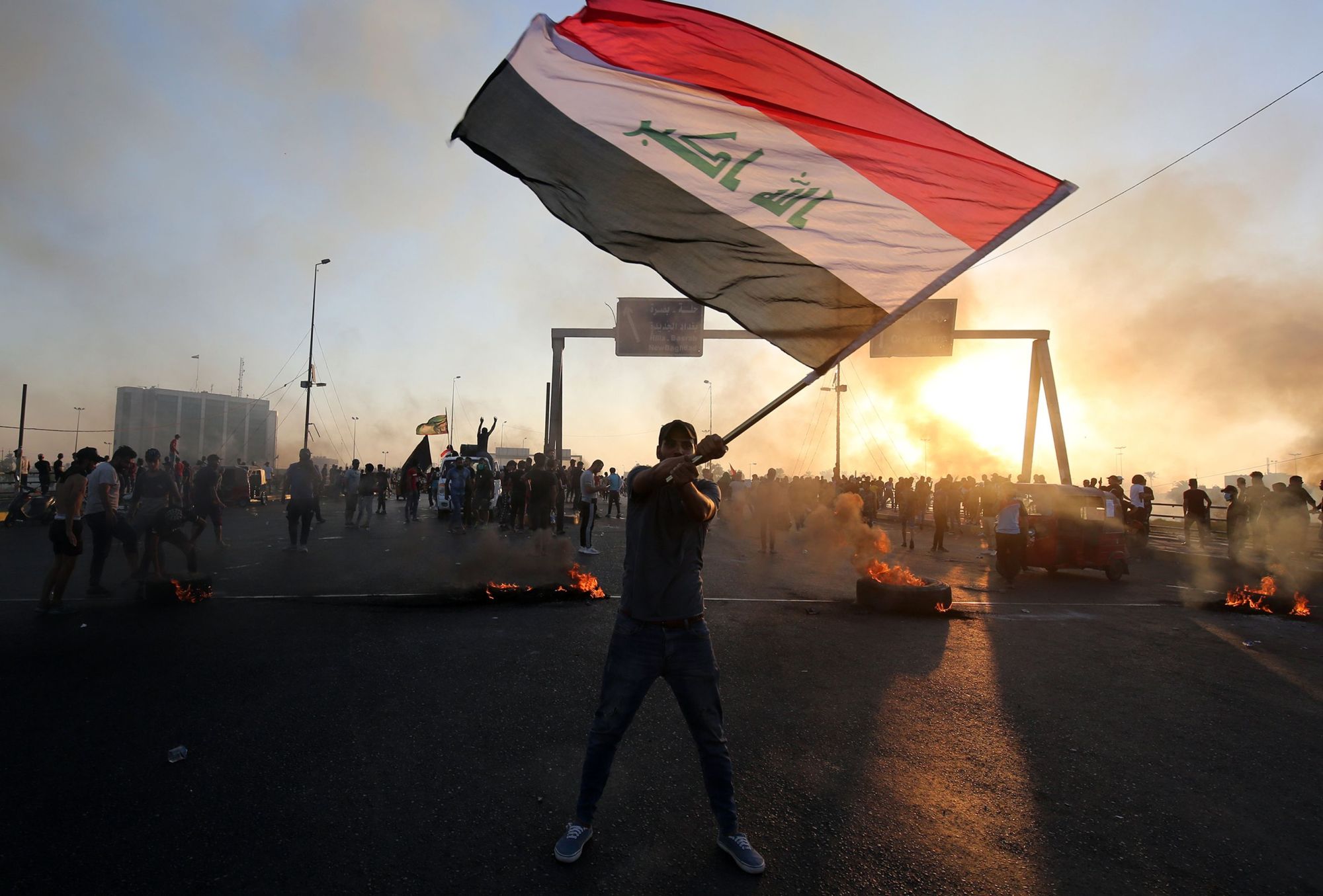A protester waves the Iraqi flag during a demonstration against state corruption, failing public services and unemployment in Baghdad on Saturday. | AFP-JIJI