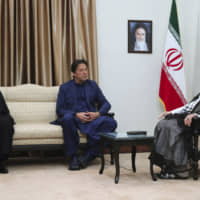 In this picture released by an official website of the office of the Iranian supreme leader, Supreme Leader Ayatollah Ali Khamenei (right) meets Pakistani Prime Minister Imran Khan as Iranian President Hassan Rouhani looks on Sunday in Tehran. A portrait of the late Iranian revolutionary founder Ayatollah Khomeini hangs on the wall. | OFFICE OF THE IRANIAN SUPREME LEADER / VIA AP