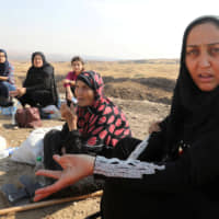Displaced Kurds stuck at the border after a Turkish offensive in northeastern Syria, wait to try cross to the Iraqi side, at the Semalka crossing, next Derik city, Syria, Monday. | REUTERS