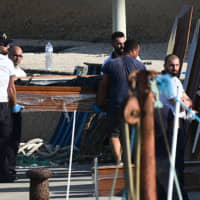 Emergency services wait to carry bodies from a migrant shipwreck that took place on Oct. 7 back to the island of Lampedusa, Italy, Thursday. | REUTERS