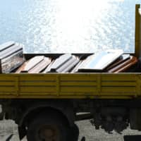 Coffins are seen as emergency services carry bodies from a migrant shipwreck that took place on Oct. 7 back to the island of Lampedusa, Italy, Thursday. | REUTERS
