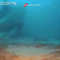 This photo grab from video taken by the Guardia Costiera Italiana, the Italian Coast Guards, on Tuesday and handed out Wednesday shows the shipwreck of a boat that was packed with around 50 migrants, that capsized on Oct. 7 off Italy\'s island of Lampedusa, resulting in the drownings of at least 13 women, some of them pregnant. | GUARDIA COSTIERA ITALIANA / ITALIAN COAST GUARDS / VIA AFP-JIJI