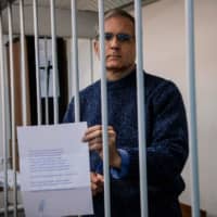 Paul Whelan, a former U.S. Marine accused of espionage and arrested in Russia in December 2018, holds a message as he stands inside a defendants\' cage before a hearing to decide to extend his detention at the Lefortovo Court in Moscow on Thursday. | AFP-JIJI