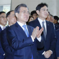 South Korean President Moon Jae-in and Samsung Electronics Vice Chairman Jay Y. Lee look around Samsung Display\'s factory in Asan, South Korea, on Thursday. | YONHAP / VIA REUTERS