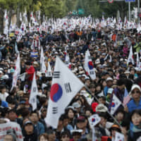 Demonstrators march near the presidential Blue House in Seoul on Oct. 9 after a rally denouncing South Korea\' then-Justice Minister Cho Kuk was held. | AP