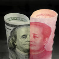 A U.S. $100 banknote and a Chinese 100 yuan banknote are seen in this photo illustration. | REUTERS