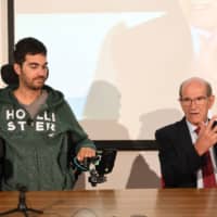 French Dr. Alim Louis Benabid (right) and patient Thibault attend a press conference to present the brain-controlled exoskeleton that allowed the patient to walk again, at the biomedical research center Clinatec in Grenoble on Monday. | AFP-JIJI