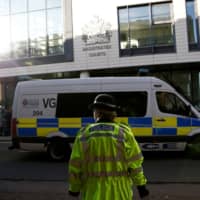 A police officer stands outside Chelmsford Magistrates\' Court, in Chelmsford, Britain, Monday. | REUTERS