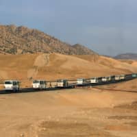 Buses carry Syrian displaced families, who fled violence amid the Turkish offensive against Syria, to displacement camps on the outskirts of Dohuk, Iraq, Thursday. | REUTERS