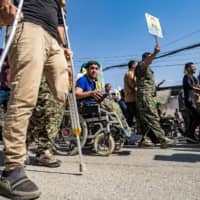 Fighters and veterans from the Kurdish women\'s protection units and the people\'s protection units march outside the U.N. headquarters in the northern Kurdish Syrian city of Qamishli during a protest against Turkish threats in the Kurdish regionTuesday. | AFP-JIJI