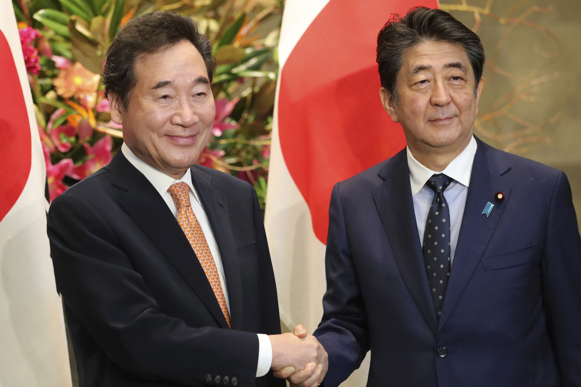 South Korea's Prime Minister Lee Nak-yon shakes hands with Prime Minister Shinzo Abe prior to their meeting at Abe's official residence in Tokyo on Thursday. | AP