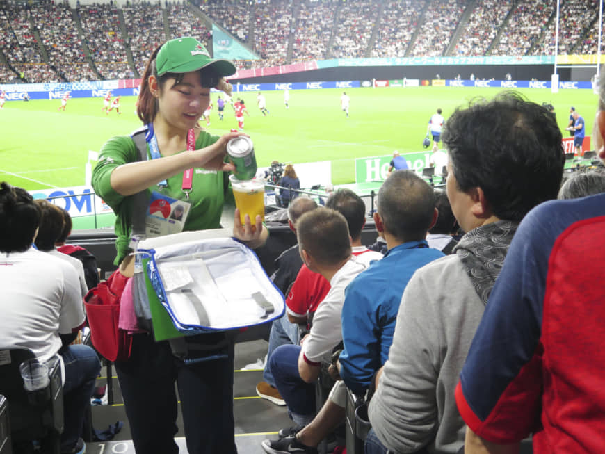 A woman sells beer during a Rugby World Cup match between England and Tonga on Sept. 22 in Sapporo. | KYODO