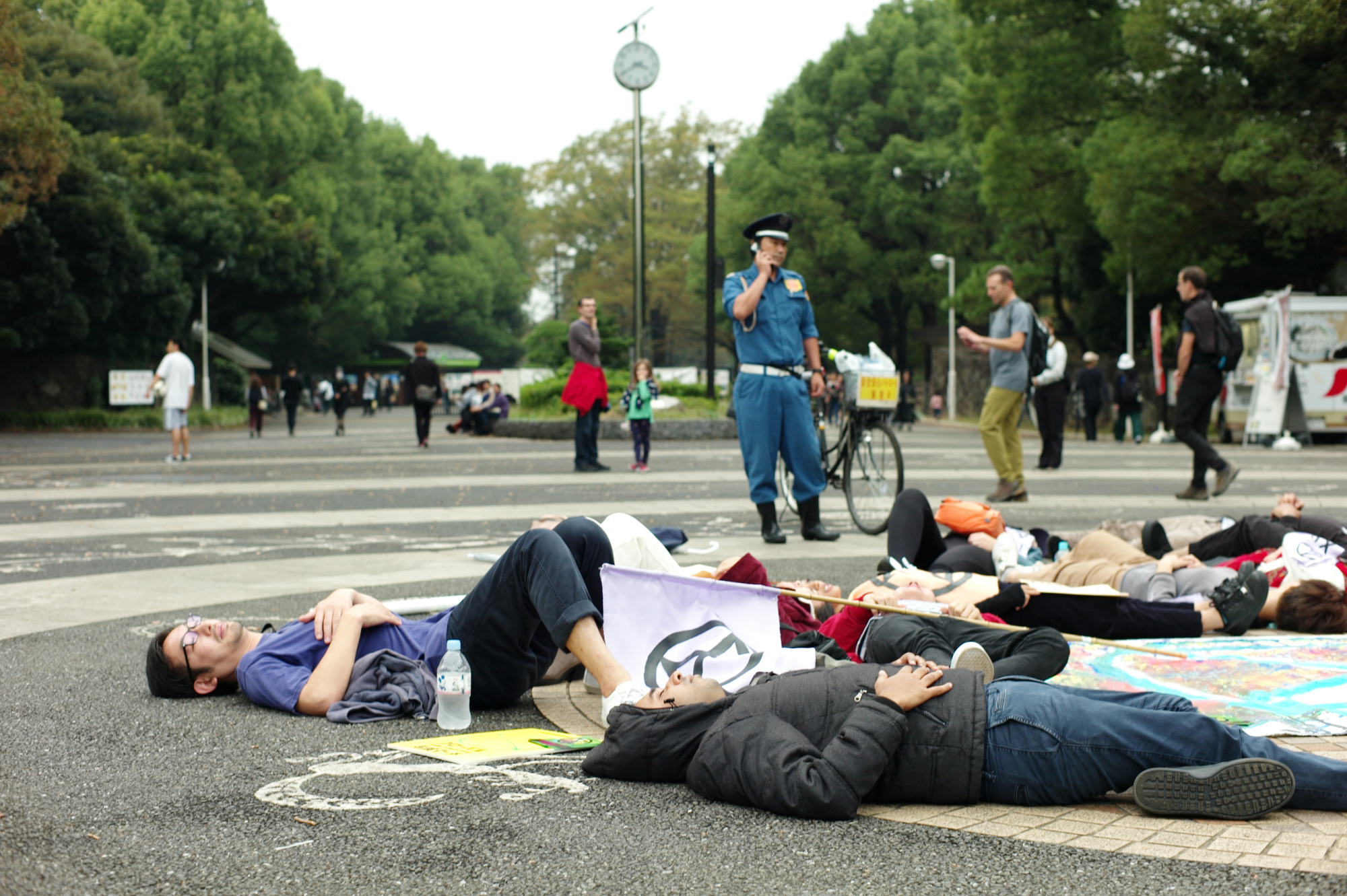 Extinction Rebellion protesters stage a 'die-in' at the entrance to Yoyogi Park on Saturday to call on the government to create a legally binding policy to reduce carbon emissions to zero by 2025. | RYUSEI TAKAHASHI