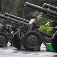 Self-Defense Forces troops prepare to fire ceremonial artillery during a proclamation ceremony marking Emperor Naruhito\'s ascension to the throne, at a park in Tokyo on Tuesday. | AFP-JIJI