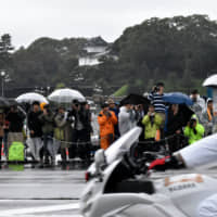 Well-wishers gather outside the Imperial Palace in Tokyo on Tuesday ahead of the enthronement ceremony for Emperor Naruhito later in the day. | SATOKO KAWASAKI