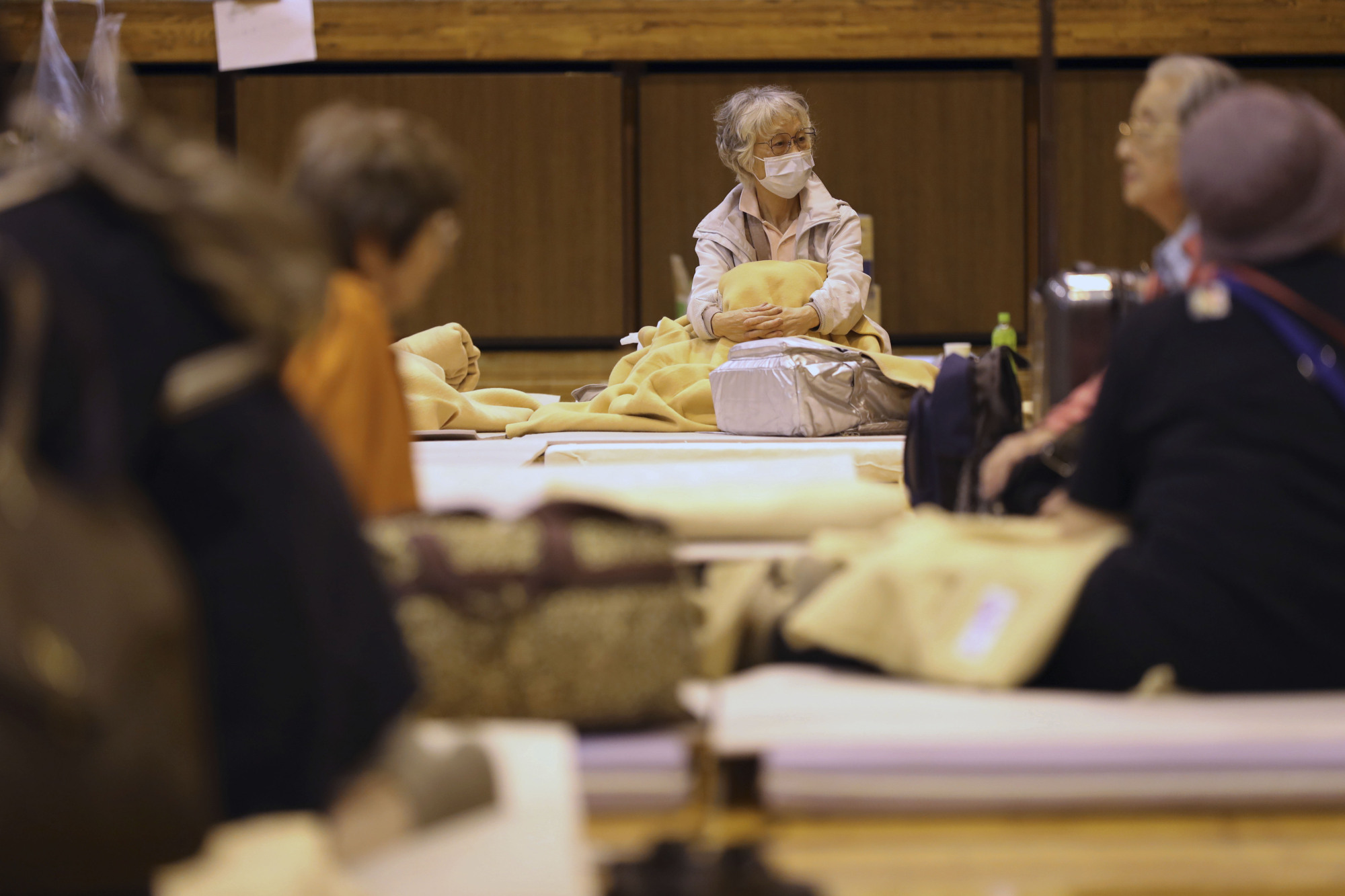 Evacuees from Typhoon Hagibis take shelter at an elementary school gym in Kawagoe, Saitama Prefecture, on Monday. An evacuation center in Taito Ward, Tokyo, turned away two homeless people on Saturday as the storm bore down on the capital. | AP