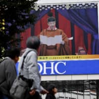 An outdoor screen in the Shinjuku district of Tokyo displays a live broadcast of Emperor Naruhito proclaiming his accession to the chrysanthemum throne on Tuesday. | AFP-JIJI