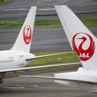 Japan Airlines aircraft are parked at Haneda Airport in Tokyo in May. | BLOOMBERG