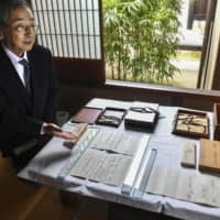 Motofuyu Okochi presents part of the oldest copy of \"The Tale of Genji\" in Kyoto on Monday. | KYODO