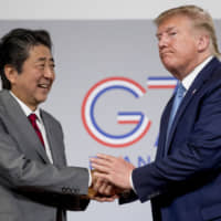 U.S. President Donald Trump and Prime Minister Shinzo Abe shake hands following a news conference on Aug. 25 at the Group of Seven summit in Biarritz, France, announcing that the U.S. and Japan had agreed in principle on a new trade agreement. | AP