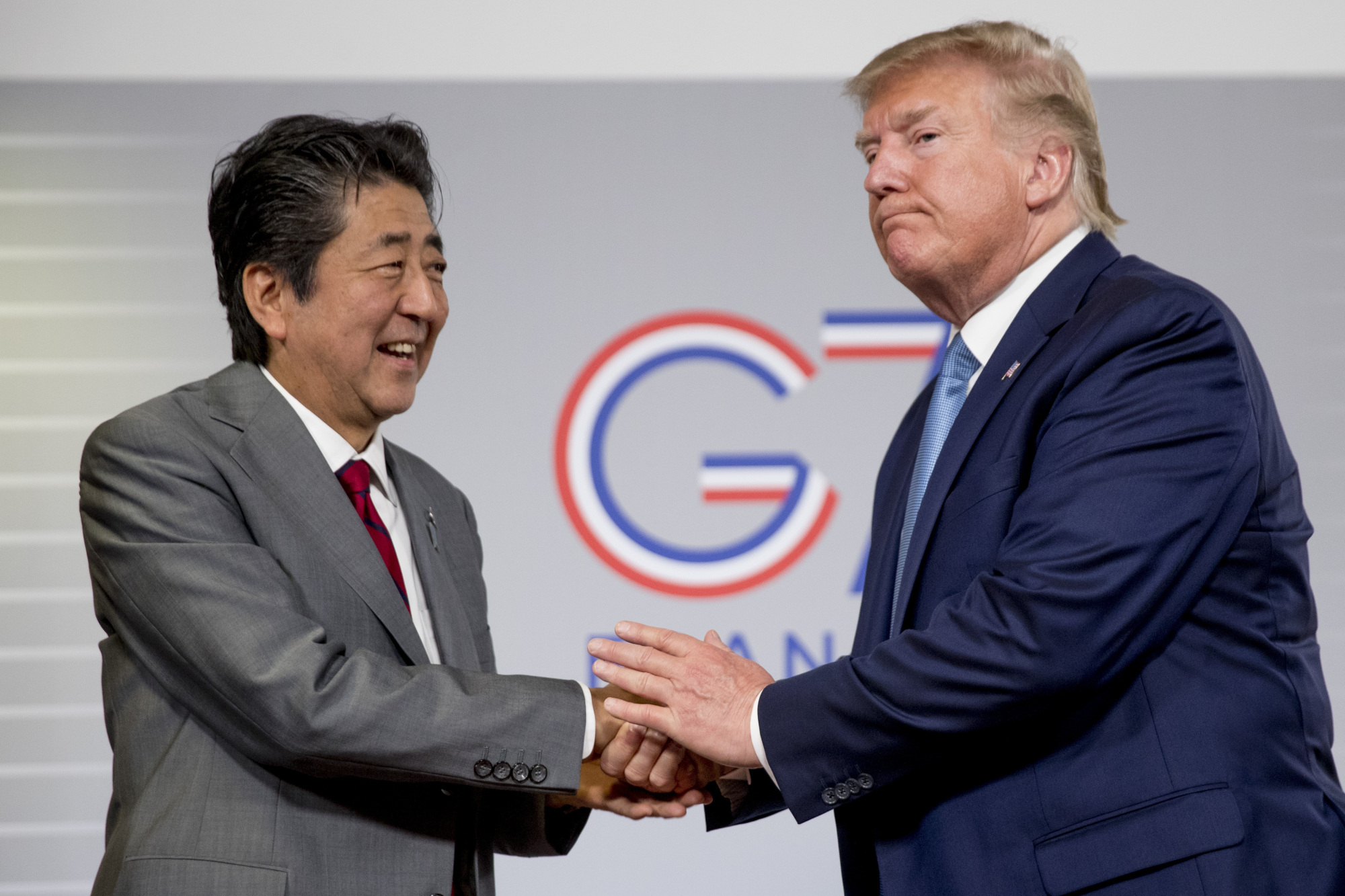 U.S. President Donald Trump and Prime Minister Shinzo Abe shake hands following a news conference on Aug. 25 at the Group of Seven summit in Biarritz, France, announcing that the U.S. and Japan had agreed in principle on a new trade agreement. | AP