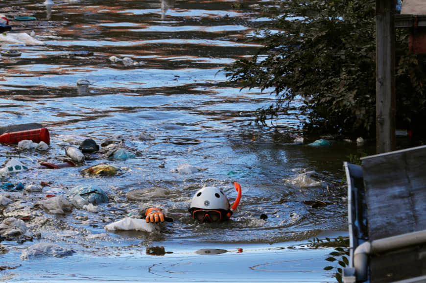 A rescue worker swims as he checks the scene around a residential area in Kawasaki on Sunday that was flooded in Typhoon Hagibis. | REUTERS