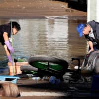 Clean-up begins in a flooded residential area in Kawasaki. | REUTERS