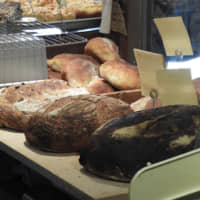 Fresh from the oven: Loaves of olive sourdough (right), Hokkaido wheat (center) and campagne (French sourdough) sit cooling on blocks in Lee\'s Bread. | JOAN BAILEY