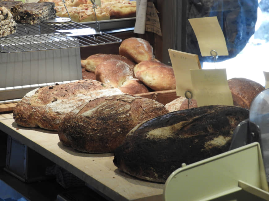 Fresh from the oven: Loaves of olive sourdough (right), Hokkaido wheat (center) and campagne (French sourdough) sit cooling on blocks in Lee's Bread. | JOAN BAILEY