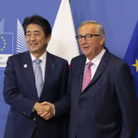 Prime Minister Shinzo Abe is greeted by European Commission President Jean-Claude Juncker prior to a meeting at EU headquarters in Brussels on Sept. 27. The new Japan-EU agreement is an important move in the right direction to meet China\'s international challenges. | AP