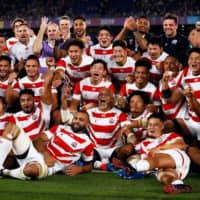 Japan\'s players pose for a group photo after winning their Rugby World Cup Pool A match against Scotland in Yokohama on Sunday. | AFP-JIJI