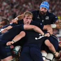 Scotland\'s Jonny Gray (center) and Blade Thomson (top right) take part in a maul on Sunday. | AFP-JIJI