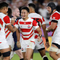 Japan\'s Kenki Fukuoka (center) is congratulated by teammate Kazuki Himeno after scoring his second try on Sunday. | AP
