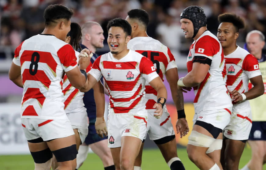 Japan's Kenki Fukuoka (center) is congratulated by teammate Kazuki Himeno after scoring his second try on Sunday. | AP