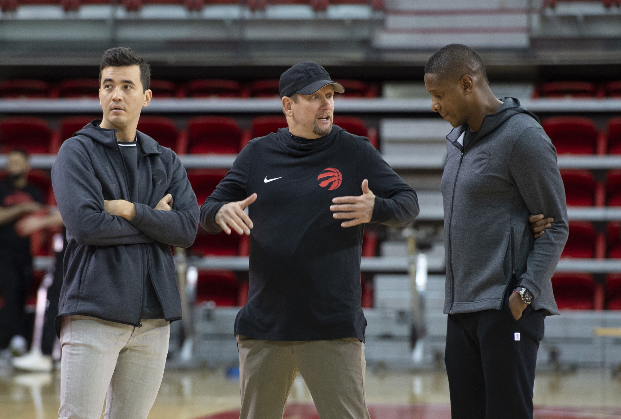Toronto Raptors head coach Nick Nurse (center) gestures while talking to team president Masai Ujiri (right) as general manager Bobby Webster looks on during an Oct. 1 practice session at Laval University in Quebec City, Quebec. | AP