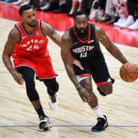 Houston\'s James Harden drives on Toronto\'s Norman Powell in NBA preseason action in Saitama on Tuesday night. | AFP-JIJI