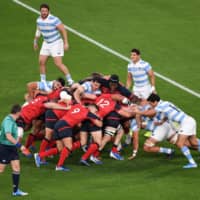 England\'s players (in red) push forward against Argentina in a Rugby World Cup Pool C match on Saturday at Tokyo Stadium. | AFP-JIJI