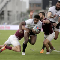Fiji\'s Frank Lomani is tackled by Georgia\'s Davit Katcharava during their Rugby World Cup Pool D game at Hanazono Rugby Stadium on Thursday. | AP