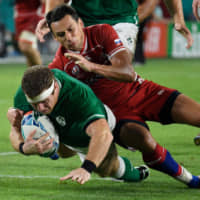 Ireland hooker Sean Cronin (left) is tackled by Russian scrumhalf Dmitry Perov during their Rugby World Cup Pool A match at Kobe Misaki Stadium on Thursday. | AFP-JIJI
