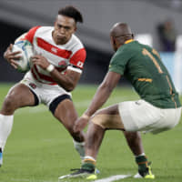 Japan\'s Kotaro Matsushima carries the ball against South Africa\'s Makazole in their Rugby World Cup quarterfinal match on Sunday night. | AP