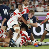 Japanese players tackle Scotland\'s Jonny Gray during the Rugby World Cup Pool A final match at International Stadium Yokohama on Sunday. | AP