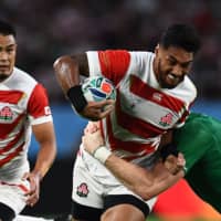 Japan center Timothy Lafaele is tackled during a Rugby World Cup Pool A match against Ireland at Shizuoka Stadium Ecopa on Saturday. | AFP-JIJI