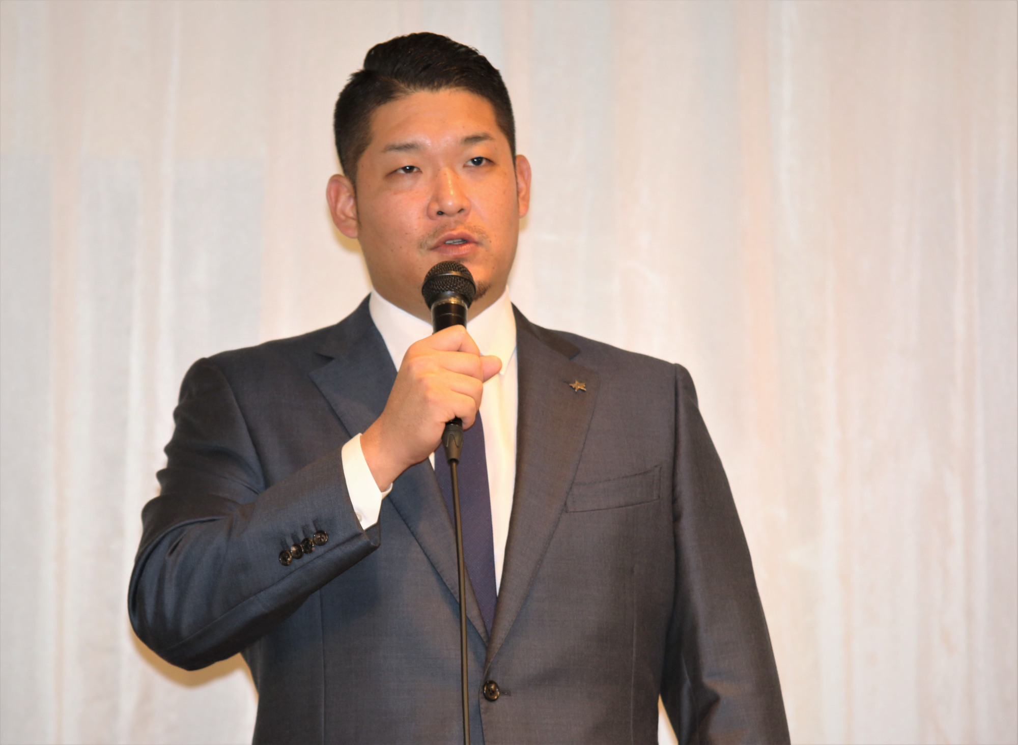 BayStars slugger Yoshitomo Tsutsugo speaks at a news conference at a Yokohama hotel on Tuesday. The 27-year-old announced his intention to go to the major leagues via the posting system this offseason. | KAZ NAGATSUKA