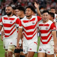 Japan full back Ryohei Yamanaka (center) walks with captain Michael Leitch (left) and center Ryoto Nakamura after Sunday\'s defeat to South Africa at Tokyo Stadium. | AFP-JIJI